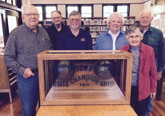 Cliff Woody (from left), Gordon Wait, David White, Martha Randel, Florence Emma Peery and Cliff Beesley surround the trophy for the 1915 Indiana state basketball champions of Thorntown High School at the town’s Public Library, 124 N. Market St. (Photo: Kyle Neddenriep / The Star)